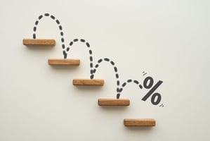 Percent sign going down steps. Concept for interest rates decreasing for home loan.