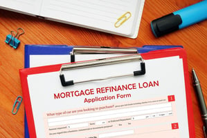 Mortgage refinance loan application on a clipboard.